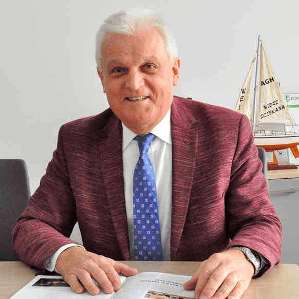 Zdjęcie profilowe Leszek Kurcz, uśmiechnięty w garniturze za biurkiem